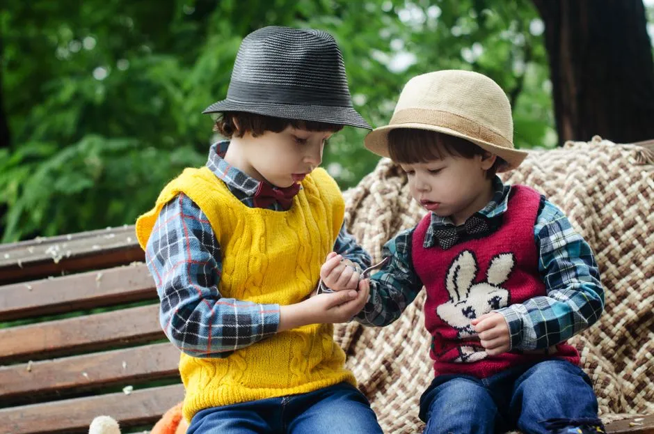 Two kids sharing a tablet in the back seat of a car, playing a bright number game